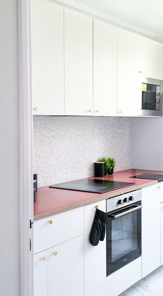 Cuisine blanche contemporaine avec plan de travail terracotta.
